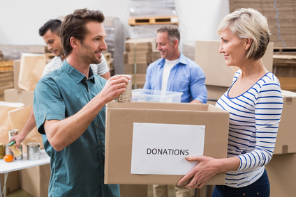 Two volunteers holding a donations box in a large warehouse